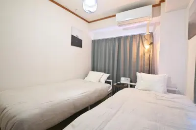a hotel room with two beds and a window at ZenAbode303 \u7fbd\u7530\u7a7a\u6e2f\u96fb\u8eca8\u5206 \u90fd\u5fc3\u30a8\u30ea\u30a2\u96fb\u8eca12\u5206 in Tokyo