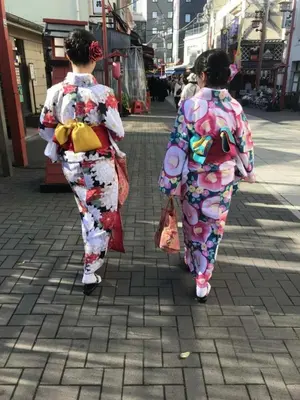 two women in kimonos walking down a street at \u30b0\u30ea\u30fc\u30f3\u30cf\u30a6\u30b9 in Tokyo