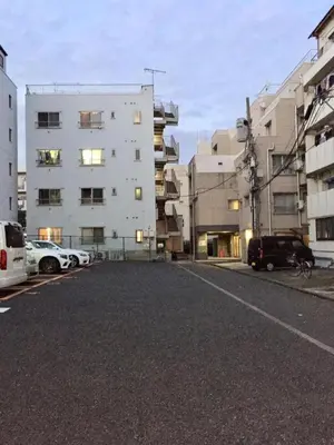 a parking lot with cars parked in front of buildings at \u30b0\u30ea\u30fc\u30f3\u30cf\u30a6\u30b9 in Tokyo
