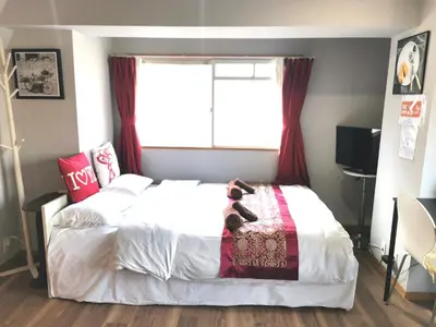 a bedroom with a bed with red curtains and a window at \u30b0\u30ea\u30fc\u30f3\u30cf\u30a6\u30b9 in Tokyo