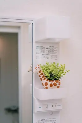 a stuffed giraffe on a shelf with a plant at Natsumi 2 \u30db\u30c6\u30eb in Tokyo