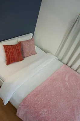 a bed with two red pillows on top of it at \u5168\u65b0\u88c5\u4fee\u5357\u54c1\u5dddhaven\u6625 in Tokyo