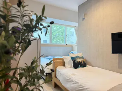 a small bedroom with a bed and a plant at nestay inn tokyo tsukiji in Tokyo