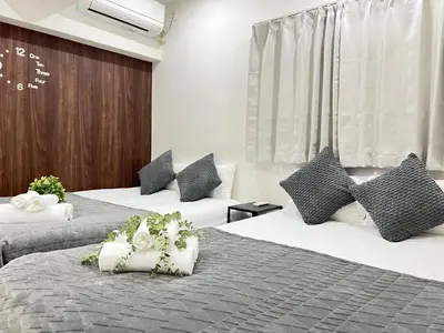 a hotel room with two beds with flowers on them at Ikebukuro Area 1F03 NishiikeApartment in Tokyo