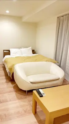 a bedroom with a white couch and a bed at Chill Fortuna Shimokitazawa Tokyo in Tokyo