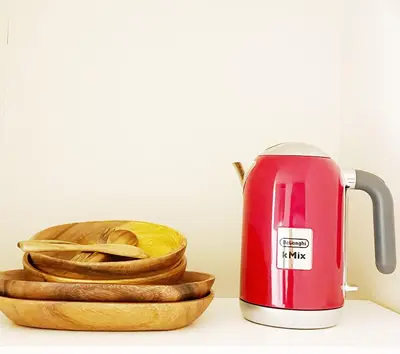 a red electric kettle next to a wooden bowl of bread at Chill Fortuna Shimokitazawa Tokyo in Tokyo