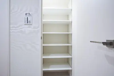 a closet with white shelves and a door at \u30a2\u30eb\u30c8\u30f4\u30a3\u30e9\u864e\u30ce\u9580 in Tokyo