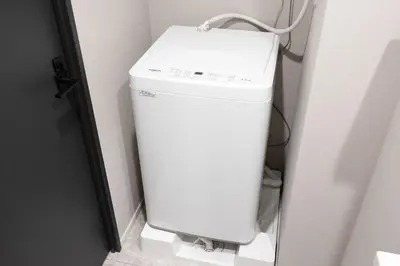 a white water heater in a corner of a room at PREAs\u4e2d\u91ce\u65b0\u4e95 in Tokyo