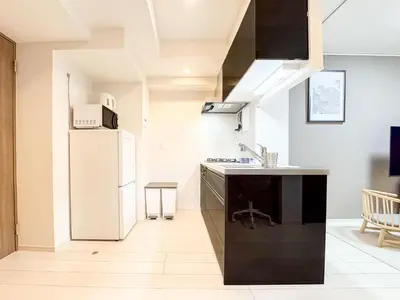 a kitchen with a white refrigerator and a counter top at Triphome Tokyo Sugamo 2024 New 3 mins 2 stations in Tokyo