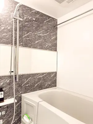 a white bath tub in a bathroom with marble tiles at Triphome Tokyo Sugamo 2024 New 3 mins 2 stations in Tokyo