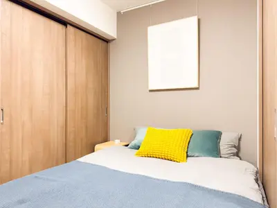 a bedroom with a bed with a yellow pillow on it at Triphome Tokyo Sugamo 2024 New 3 mins 2 stations in Tokyo