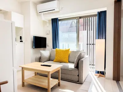 a living room with a couch and a table at Triphome Tokyo Sugamo 2024 New 3 mins 2 stations in Tokyo