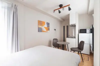 a bedroom with a bed and two chairs and a table at Jeunesse\u7acb\u82b1 in Tokyo