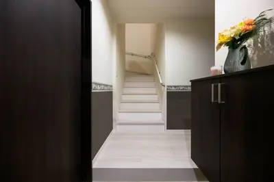 a hallway with stairs and a vase of flowers at Origami-ya Stay Zen - Luxury Asakusa Penthouse in Tokyo