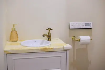 a bathroom with a sink and a clock on the wall at Origami-ya Stay Akari - Luxury Asakusa Penthouse in Tokyo