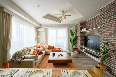 a living room with a couch and a brick wall at Origami-ya Stay Akari - Luxury Asakusa Penthouse in Tokyo
