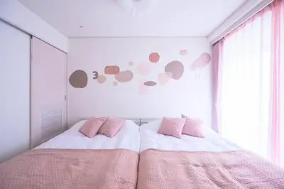 a bedroom with a bed with pink pillows and a window at Origami-ya Stay Akari - Luxury Asakusa Penthouse in Tokyo