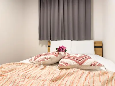 a bed with two pillows and a pink flower on it at japan house Ikebukuro 2 in Tokyo