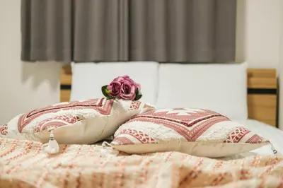 a bed with two pillows and a rose on it at japan house Ikebukuro 2 in Tokyo