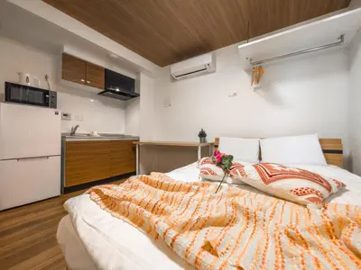 a large bed in a room with a kitchen at japan house Ikebukuro 2 in Tokyo