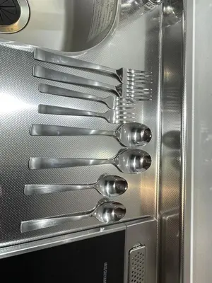 a group of silver spoons sitting on top of a microwave at japan house Ikebukuro 2 in Tokyo