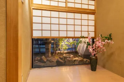 a window with a vase of flowers on a table at \u8aa0\u5fc3\u58024f in Tokyo
