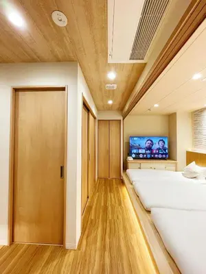 a room with two beds and a flat screen tv at Etsu in Tokyo