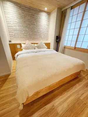 a large bed in a room with a large window at Etsu in Tokyo