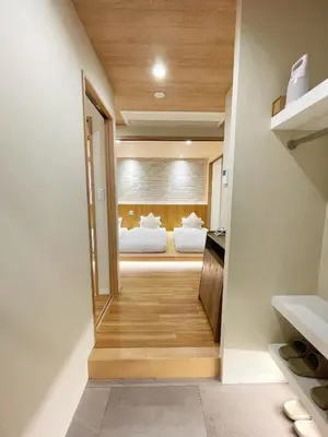 a hallway leading to a bedroom with two beds at Etsu in Tokyo