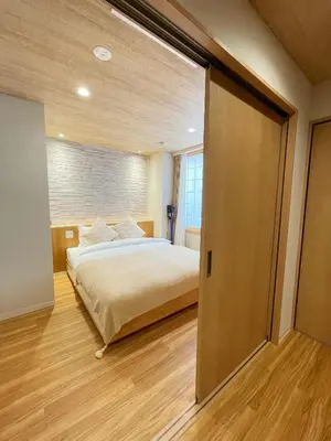 a bedroom with a bed and a sliding door at Etsu in Tokyo