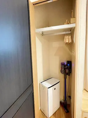 a small white refrigerator in a room with a door at Etsu in Tokyo
