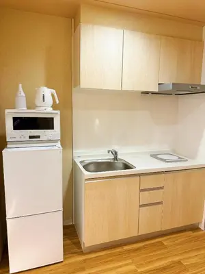 a small kitchen with a sink and a microwave at Etsu in Tokyo