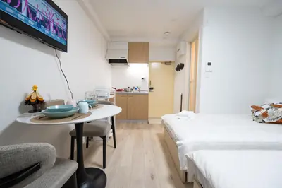 a room with two beds and a table with a tv at Home Story in Tokyo \u6c5f\u6238\u5ddd\u533a\u5e73\u4e95\u99c5-\u4e0a\u91ce \u79cb\u8449\u539f\u307e\u3067\u76f4\u901a in Tokyo