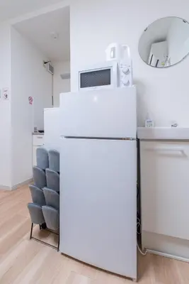 a white kitchen with a microwave on top of a refrigerator at A 3rooms MAX8people 6min Shinjuku 11min Shibuya 12min walk Ikebukuro LEON RESORT IKEBUKURO traditional Japanese room \u6c60\u888b \u6700\u59278\u540d in Tokyo