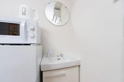 a white kitchen with a sink and a microwave at A 3rooms MAX8people 6min Shinjuku 11min Shibuya 12min walk Ikebukuro LEON RESORT IKEBUKURO traditional Japanese room \u6c60\u888b \u6700\u59278\u540d in Tokyo