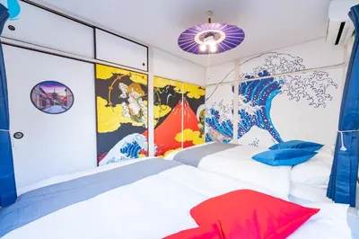 a bedroom with two white beds and a mural at A 3rooms MAX8people 6min Shinjuku 11min Shibuya 12min walk Ikebukuro LEON RESORT IKEBUKURO traditional Japanese room \u6c60\u888b \u6700\u59278\u540d in Tokyo