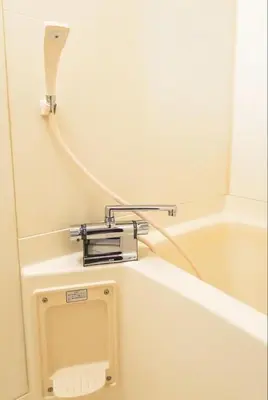 a bathroom with a bath tub with a toilet paper dispenser at Shirokane Apartment Hotel 3 in Tokyo