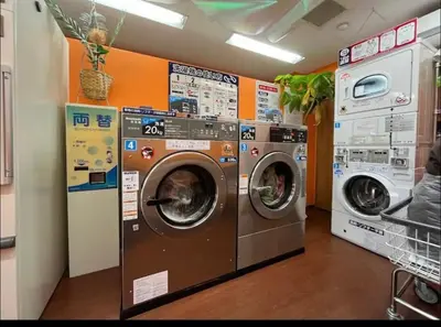 a laundry room with three washing machines in a store at Shirokane Apartment Hotel 3 in Tokyo