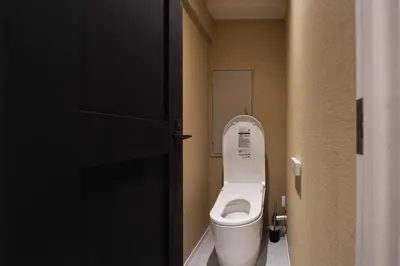 a small bathroom with a toilet with the lid up at Real Life IIDABASHI in Tokyo