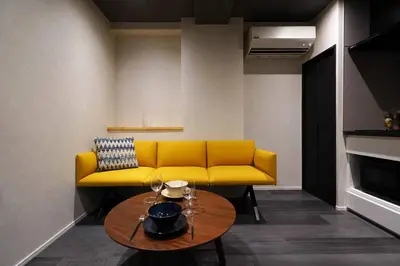 a yellow couch in a living room with a table at Real Life IIDABASHI in Tokyo