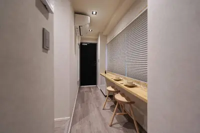 a hallway with a long table and two stools at Real Life IIDABASHI in Tokyo