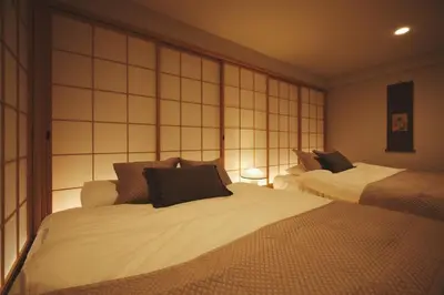 a hotel room with two beds in a bedroom at New open \u90fd\u5fc3\u306e\u4e00\u8ed2\u5bb6\u8cb8\u5207 232\u5e73\u7c73 \u65b0\u5bbf\u99c54\u5206 \u6e0b\u8c3710\u5206 \u7121\u6599\u99d0\u8eca\u58343\u53f0 \u6700\u5bc4\u99c52\u5206 in Tokyo