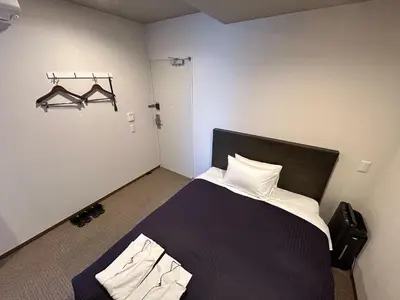 a bedroom with a black bed with white pillows at HOTEL LiVEMAX Mita Ekimae in Tokyo