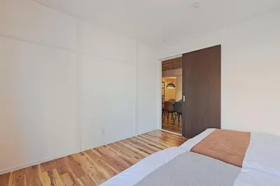 a white bedroom with a bed and a wooden door at V Close to Shinjuku Kabukicho Korean Town FrWIFI K in Tokyo