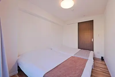 a bedroom with a large white bed with a wooden floor at V Close to Shinjuku Kabukicho Korean Town FrWIFI K in Tokyo