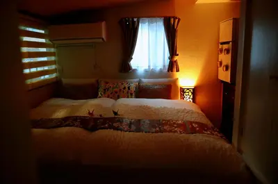 a bedroom with a bed and a window at Ayaka's House in Tokyo