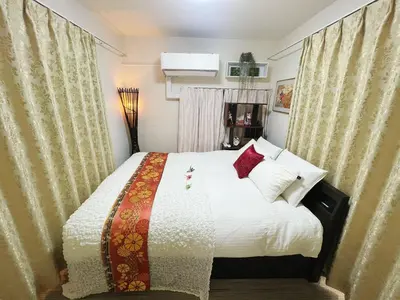 a bedroom with a bed with white sheets and red pillows at Ayaka's House in Tokyo
