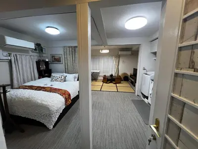 a bedroom with a bed and a living room at Ayaka's House in Tokyo