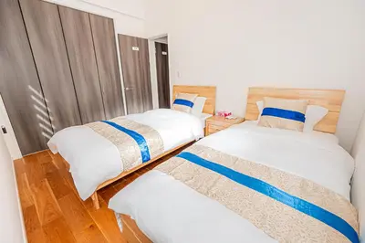 two beds in a room with wooden floors at Arashi hotel \u5d50\u30db\u30c6\u30eb in Tokyo