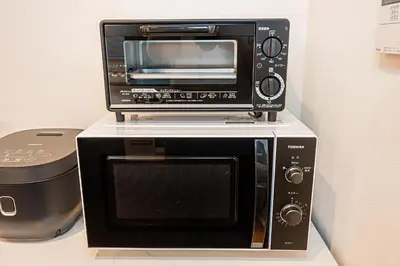a microwave sitting on top of a toaster oven at Arashi hotel \u5d50\u30db\u30c6\u30eb in Tokyo